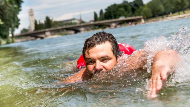 Benjamin David schwimmt in der Isar in München