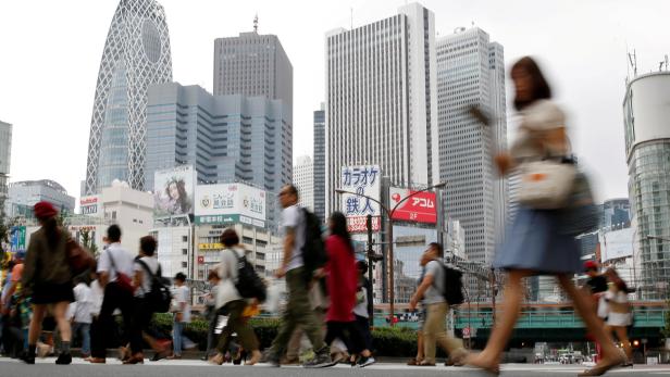 FILE PHOTO: People cross a street in front of high-rise buildings in the Shinjuku district in Tokyo, Japan, September 29, 2016. REUTERS/Toru Hanai/File Photo