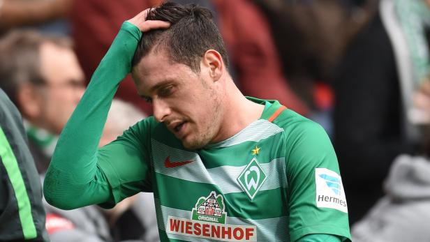Ein enttäuschter Fußballspieler von Werder Bremen greift sich an den Kopf.