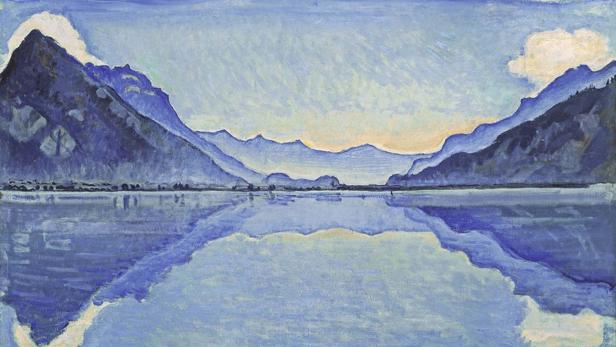 Ein Gemälde einer Berglandschaft, die sich in einem ruhigen See spiegelt.