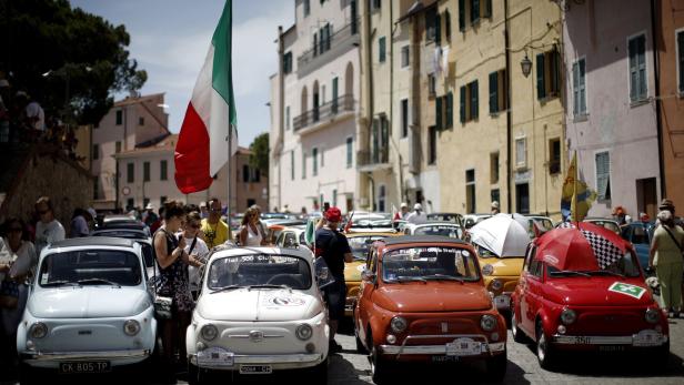 TOPSHOT - People take part at the 34th International Rally of Fiat 500 Club Italia for the 60th anniversary of this car on July 8, 2017, in Garlenda, near Genoa. \r More than 1200 cars came from Europe to take part at the 34 rally of Garlenda to celebrate the 60th anniversary of the Fiat 500. / AFP PHOTO / Marco BERTORELLO