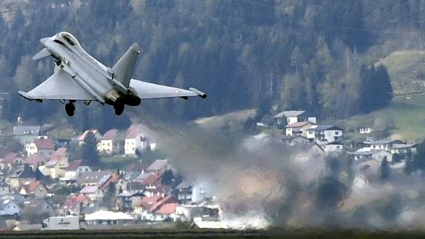 Ein Eurofighter steigt über einer Ortschaft auf.