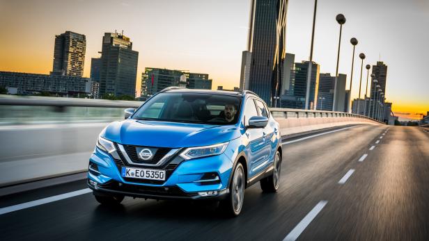 Ein blauer Nissan Qashqai fährt auf einer Straße in Wien.