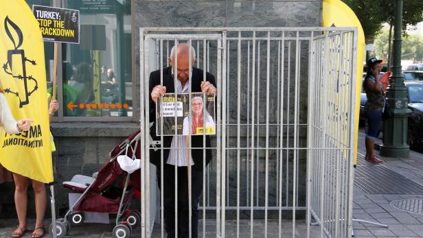 Der belgische Amnesty-Direktor demonstriert in einem Käfig für die Freilassung.