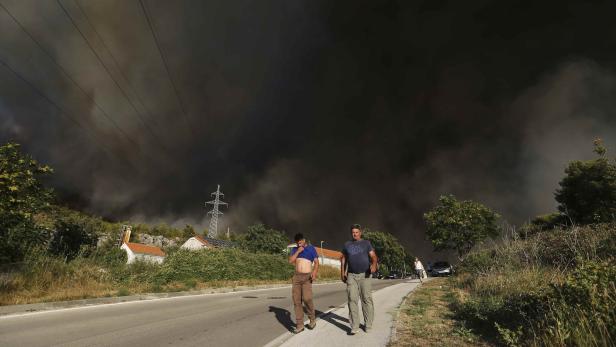 Smoke rises as local residents leave their homes due to a wildfire in the village of Mravinc near Split, Croatia, July 17, 2017. REUTERS/Antonio Bronic