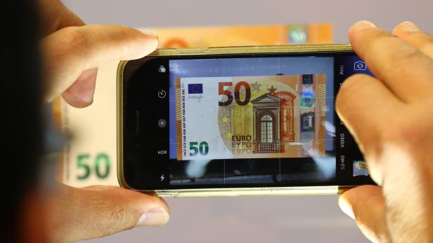 Ein Journalist fotografiert den im April vorgestellten neuen 50-Euro-Schein