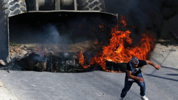 Ein Palästinenser flüchtet vor einem Bulldozer bei Zusammenstößen in Kobar.