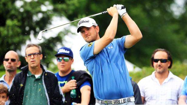 Ein Golfspieler schwingt seinen Schläger vor einer Zuschauermenge.