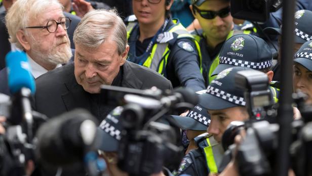 Melbourne: George Pell wird von Polizisten vor dem Medienansturm geschützt.