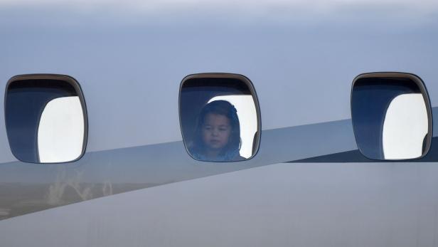 Princess Charlotte looks through the window of the plane as Britain&#039;s Prince William (Unseen), Duke of Cambridge and his wife Kate (Unseem), the Duchess of Cambridge arrive at the Tegel airport in Berlin on July 19, 2017. The British royal couple is on a three-day visit in Germany. / AFP PHOTO / dpa / Bernd von Jutrczenka / Germany OUT