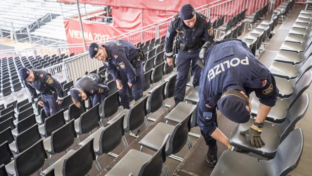 Polizei-Beamte untersuchen die Sitzplätze im Stadion