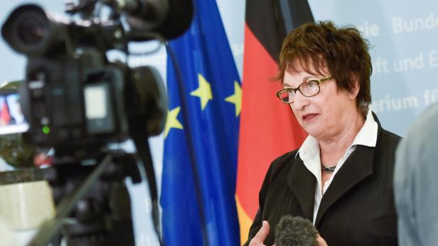 Eine Frau spricht vor Mikrofonen, im Hintergrund sind die Europa- und Deutschlandflagge zu sehen.