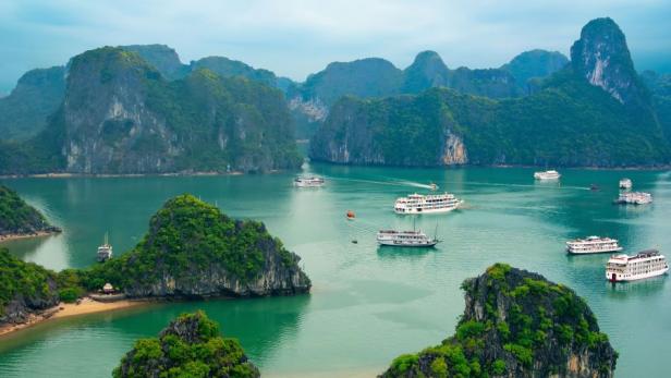 Tourist junks floating among limestone rocks at ea… Tourist junks floating among limestone rocks at early morning in Ha Long Bay, South China Sea, Vietnam, Southeast Asia. Two images panorama