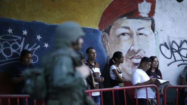 Unter dem wachsamen Auge der Erben des verstorbenen sozialistischen Präsidenten Chávez stehen Bürger in Caracas für Stimmabgabe an