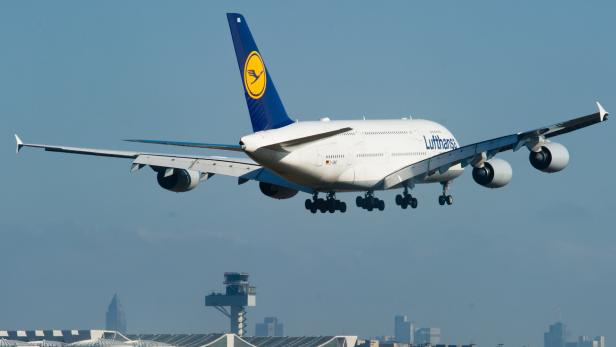 Ein Lufthansa A380 landet vor der Skyline von Frankfurt.