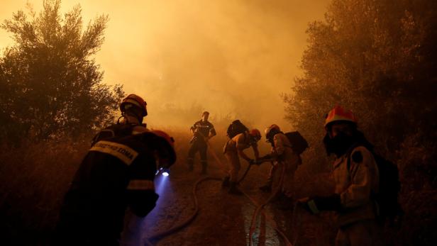 Feuerwehrleute kämpfen gegen die Flammen an.