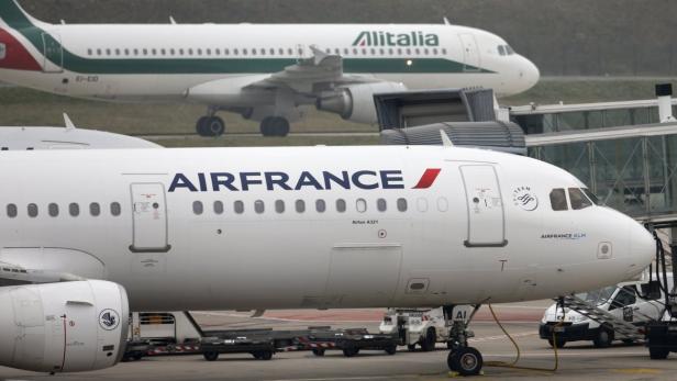 An Alitalia plane passes an Air France plane on the tarmac of Charles de Gaulles International Airport in Roissy near Paris, January 8, 2013. Investors in Alitalia who helped rescue the airline four years ago are considering selling their shares, with some pushing for a deal with long-time stakeholder Air France-KLM, sources with knowledge of the situation said on Monday, January 7, 2013. REUTERS/Charles Platiau (FRANCE - Tags: TRANSPORT BUSINESS)