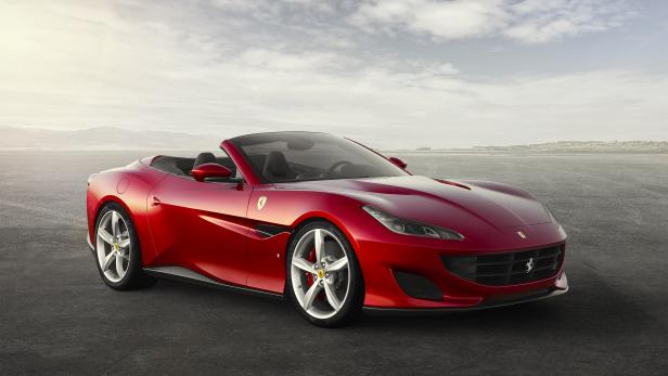 Ein roter Ferrari Portofino Spider steht auf einer asphaltierten Fläche.