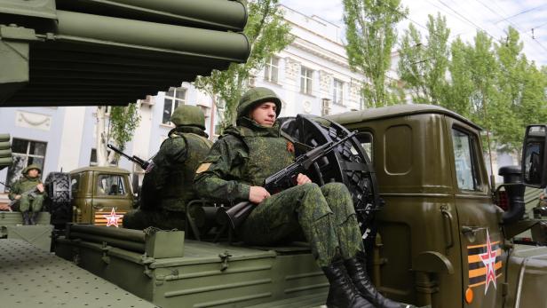 Ein Soldat, der auf einem Kriegs-Fahrzeug sitzt