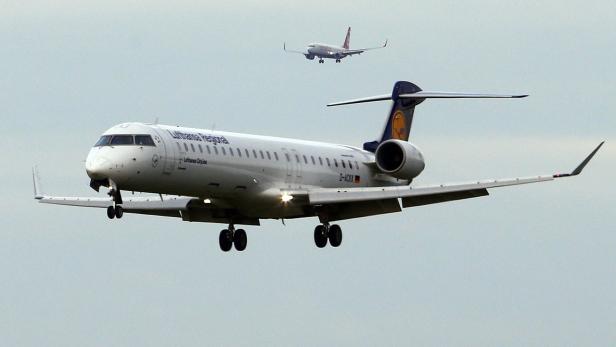 Ein Lufthansa Regional Flugzeug landet, ein weiteres Flugzeug ist im Hintergrund zu sehen.