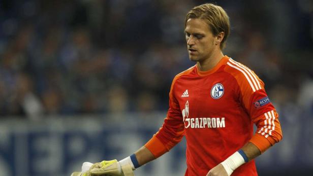 Ein Torwart des FC Schalke 04 in oranger Spielkleidung.