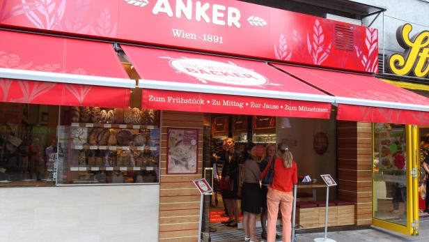 Eine Gruppe von Frauen steht vor einer Filiale der Bäckerei Anker in Wien.