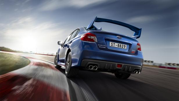 Ein blauer Subaru WRX fährt auf einer Rennstrecke.