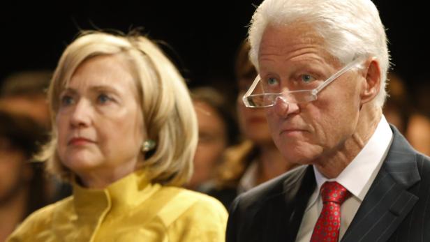 Hillary und Bill Clinton sitzen nebeneinander bei einer Veranstaltung.