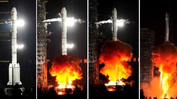 Eine Rakete startet mit einer großen Feuerwolke in den Nachthimmel.