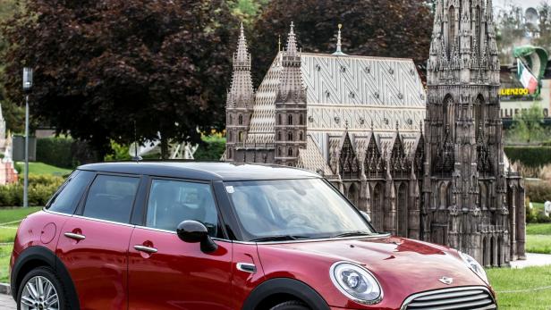 Ein roter Mini Cooper vor dem Miniatur-Stephansdom in Wien.