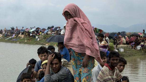 Vertriebene Rohingya an der Grenze zu Bangladesch - während am Horizont ihre Dörfer brennen.