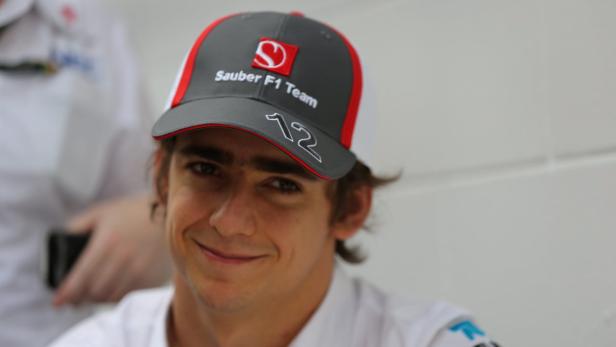 Ein junger Mann mit einer „Sauber F1 Team“-Kappe lächelt in die Kamera.