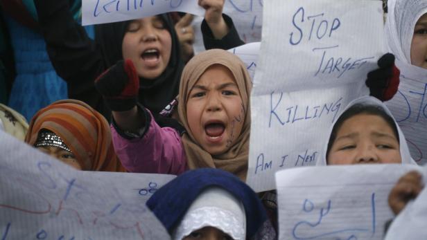 Shi&#039;ite Muslims girls hold placards as they shout slogans during a protest near the covered bodies (not in picture) of Saturday&#039;s bomb attack victims during a sit-in in Quetta February 18, 2013. Pakistani Shi&#039;ites furious over a sectarian bombing that killed 85 people protested on Monday, demanding that security forces protect them from hardline Sunni groups. REUTERS/Naseer Ahmed (PAKISTAN - Tags: POLITICS CIVIL UNREST CRIME LAW RELIGION)