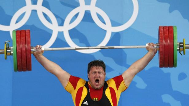 Ein Gewichtheber der deutschen Nationalmannschaft stemmt eine Hantel über seinem Kopf.