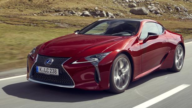 Ein roter Lexus LC fährt auf einer Landstraße.