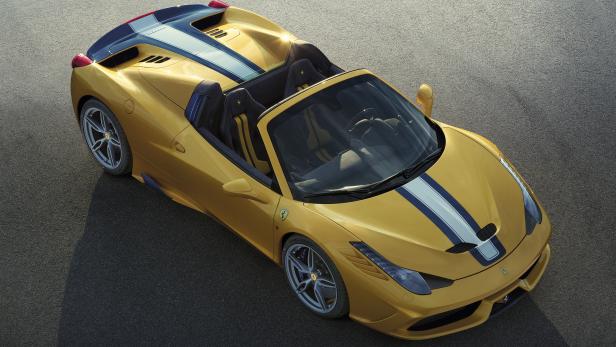 Ein gelber Ferrari 458 Spider mit blauen und weißen Streifen auf einer Asphaltstraße.