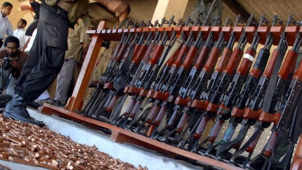 Eine Sammlung von AK-47-Gewehren und Munition wird präsentiert.