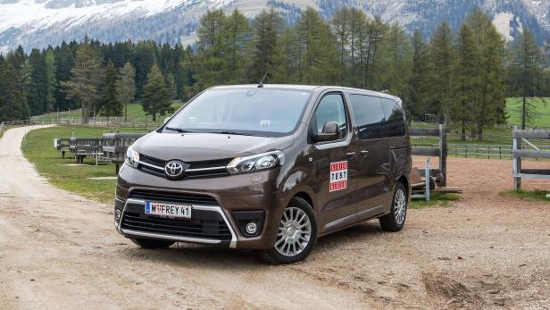 Ein brauner Toyota Proace steht vor einer Berglandschaft.
