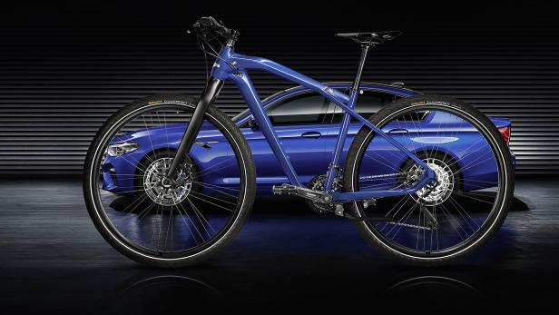 Ein blaues BMW-Fahrrad steht vor einem blauen BMW-Auto.