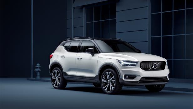 Ein weißer Volvo XC40 steht vor einem Gebäude mit dunkler Fassade.