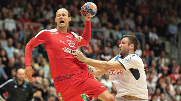 HANDBALL-WORLD-DEN-AUT Ein Handballspieler im roten Trikot wirft den Ball, während ein Gegenspieler ihn zu stoppen versucht.
