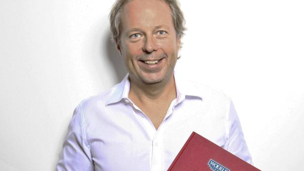 Ein lächelnder Mann im Hemd hält ein Buch mit dem Titel „Woerle 5 Generationen“.