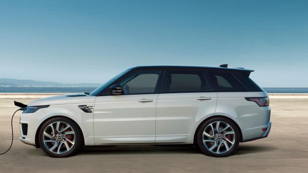 Ein weißer Range Rover wird an einer Ladestation aufgeladen.