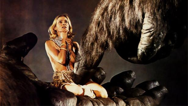 Eine Frau sitzt in der Hand eines riesigen Affen, möglicherweise eine Szene aus dem Film „King Kong“.