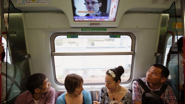 Passagiere in Hongkong - im TV Edward Snowden, der US-Überwachungsprogramme enthüllt hat