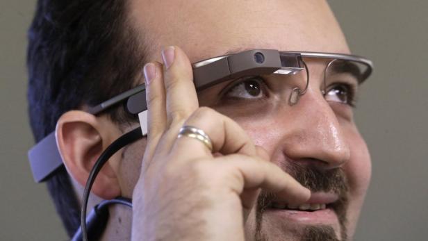 Ein Mann mit Google Glass justiert die Brille am Kopf.