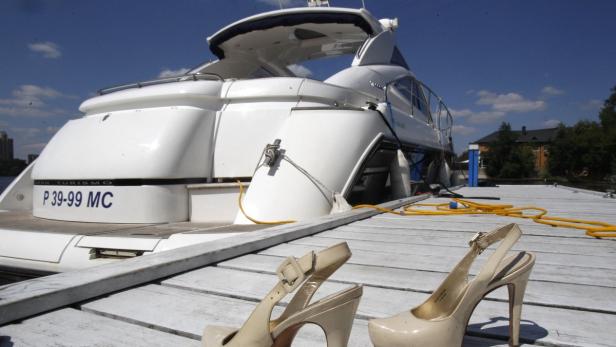 A pair of high heel shoes is placed on shore in front of a yacht during the summer contingent of the Millionaire Fair of luxury goods in Moscow, July 4, 2010. REUTERS/Sergei Karpukhin (RUSSIA - Tags: BUSINESS SOCIETY)