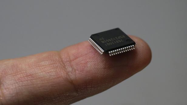 Mikrochip auf Finger.