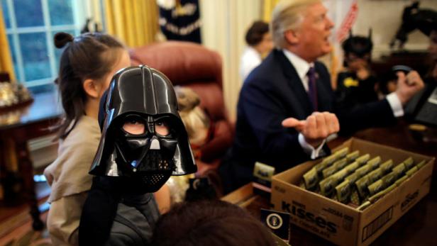 U.S. President Donald Trump gives out Halloween treats to children of members of press and White House staff at the Oval Office of the White House in Washington, U.S., October 27, 2017. REUTERS/Carlos Barria
