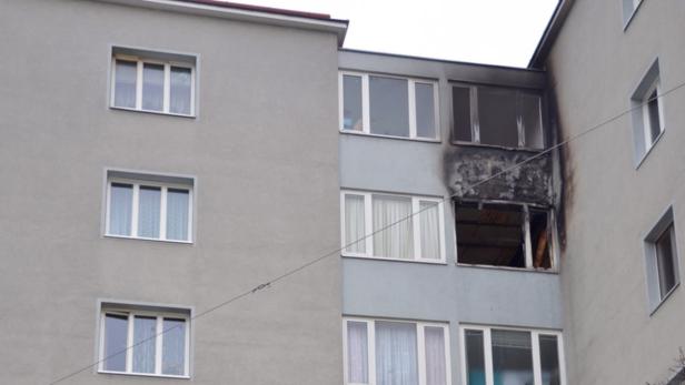 Ein Wohnhaus mit Brandschaden an einem Balkon.
